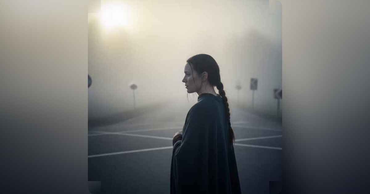 Person standing at a foggy crossroads contemplating the path ahead