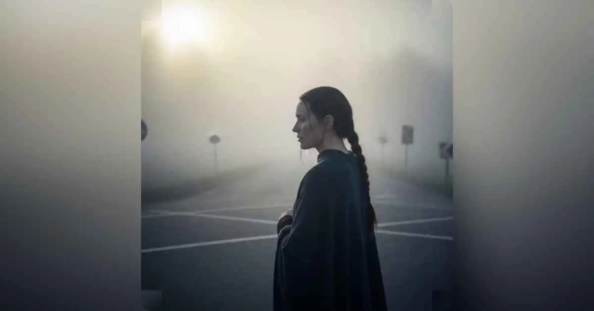 Person standing at a foggy crossroads contemplating the path ahead