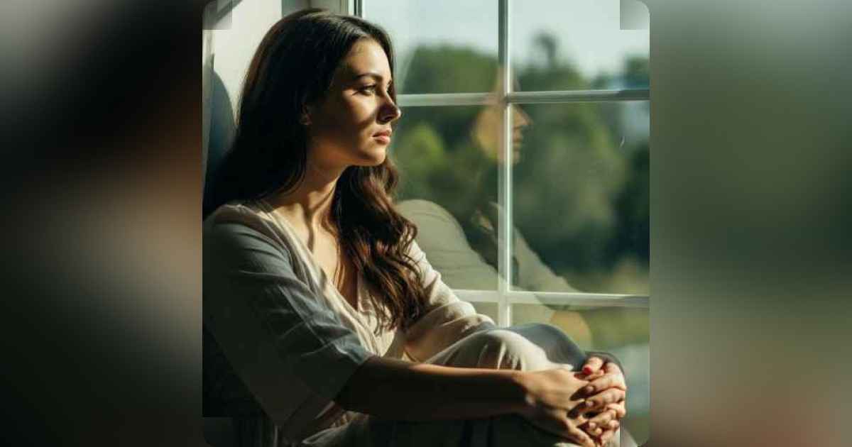A person sitting alone, looking out a window, deep in thought